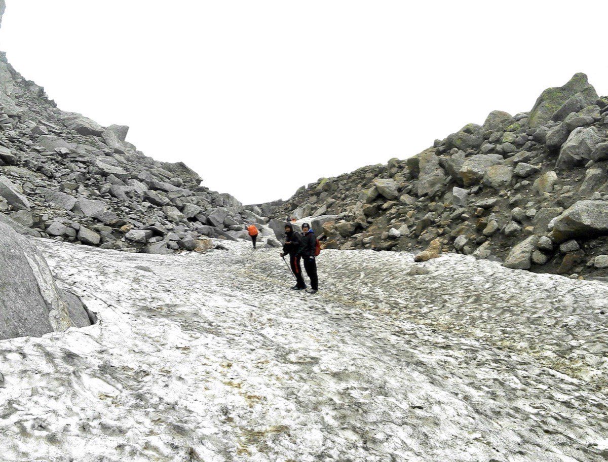 Trekkers celebrating below dramatic peaks near Hampta Pass